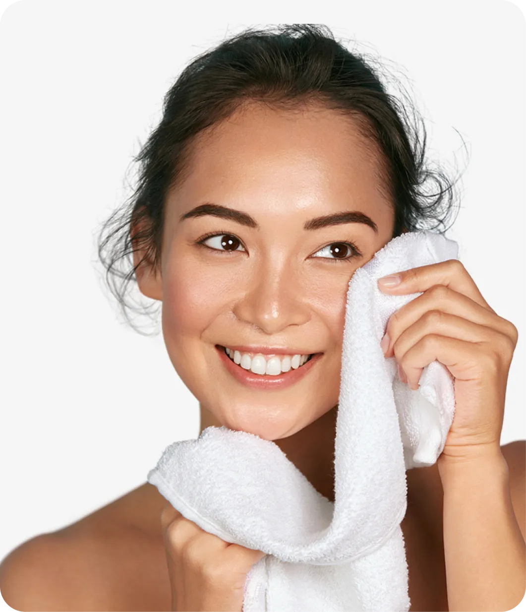 Smiling woman holding a white towel to her face